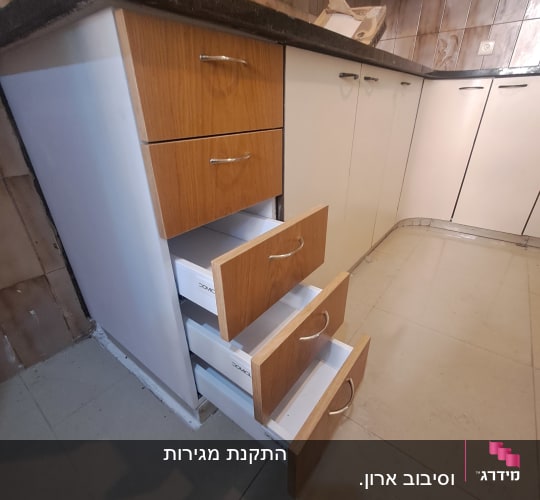 מגירות עץ פתוחות במטבח עם משטח כהה